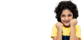 Kind hält zwei Fäuste auf Kopfhöhe vor sich und lächelt in die Kamera