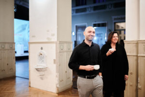 Mann und Frau halten Tasse in der Hand und Mann lächelt in die Kamera