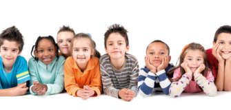 Kinder liegen nebeneinander und lächeln in die Kamera