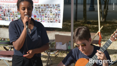 Eine Jugendliche singt und ein Jugendlicher begleitet sie mit der Gitarre. Text im unteren rechten Abschnitt des Bildes: "Bregenz"