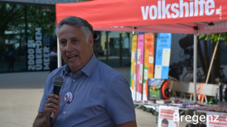 Mann redet ins Mikrofon, im unteren rechten Bereich des Bildes steht "Bregenz"