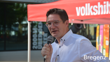 Mann redet ins Mikrofon, im unteren rechten Bereich des Bildes steht "Bregenz"