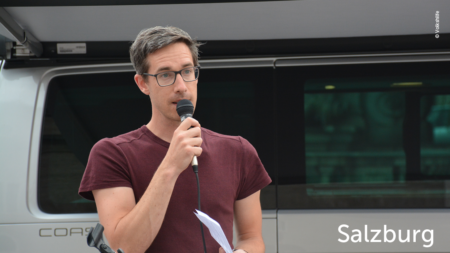 Mann hält eine Rede, im unteren rechten Abschnitt des Bildes steht "Salzburg"