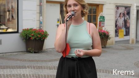 Eine Frau hält eine Rede, im unteren rechten Abschnitt des Bildes steht "Krems"