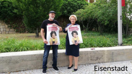 Erich Fenninger und eine ältere Frau halten zwei Volkshilfe Plakate in die Höhe mit der Aufschrift: "Wir können Kinderarmut abschaffen!", im unteren rechten Abschnitt des Bildes steht "Eisenstadt"