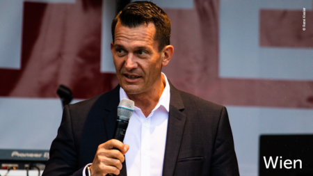 Ein Mann hält eine Rede, im unteren rechten Abschnitt des Bildes steht "Wien"