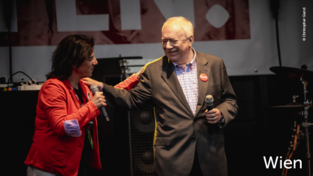 Volkshilfe Wien Präsident Michael Häupl und Volkshilfe-Wien-Geschäftsführerin Tanja Wehsely stehen auf der Bühne und umarmen sich leicht. Im unteren rechten Abschnitt des Bildes steht: "Wien"