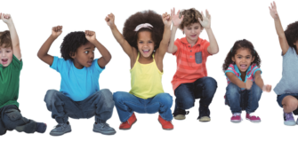 Mehrere Kinder knien nebeneinander auf dem Boden und halten jubelnd ihre Hände in die Höhe