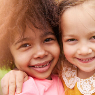 Zwei Mädchen lächeln in die Kamera